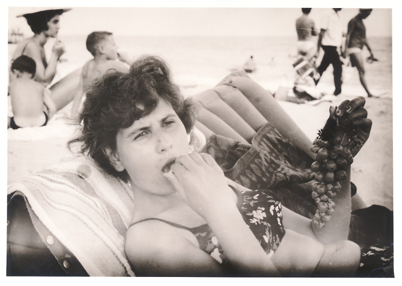 Frau isst am Strand Weintrauben